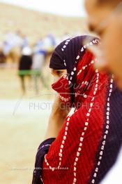 Image du Maroc Professionnelle de  Une jeune fille du désert habillée d'une tenue traditionnelle regarde la course de chameau durant le grand Moussem de Tan Tan. Ce grand rassemblement est organisé dans un site désertique sur lequel la ville de Tan Tan a toujours accueilli la majorité des tribus et des grandes familles nomades du désert lors d'un grand moussem, Samedi 18 septembre 2004. (Photo / Abdeljalil Bounhar)




